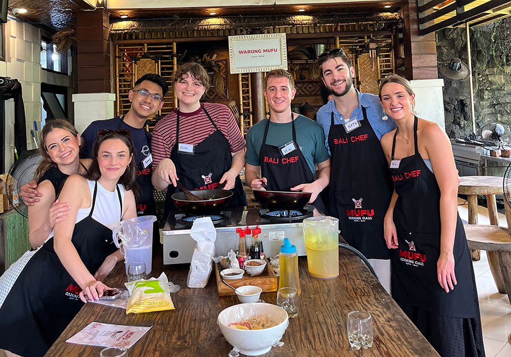 Local instructor guiding guests during a Bali cooking class at Warung Mufu